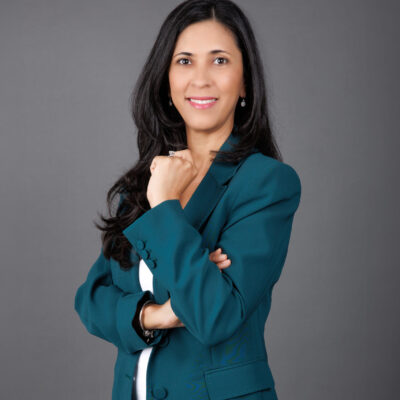 Meet Michelle Appanah, your Regional Director for Mauritius at RedLac Real Estate. A passionate gardening enthusiast and expert in property investment, she exudes confidence with her long dark hair cascading over a teal blazer paired with a white top. Posed against a sleek gray background, her slight smile is inviting. Discover opportunities with RedLac Real Estate Dubai, where expertise meets exceptional property investments.