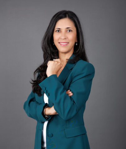 Meet Michelle Appanah, your Regional Director for Mauritius at RedLac Real Estate. A passionate gardening enthusiast and expert in property investment, she exudes confidence with her long dark hair cascading over a teal blazer paired with a white top. Posed against a sleek gray background, her slight smile is inviting. Discover opportunities with RedLac Real Estate Dubai, where expertise meets exceptional property investments.