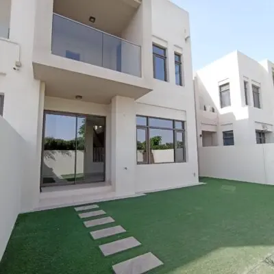 This modern two-story villa for rent in Mira Oasis showcases a sleek design with its striking white facade and expansive windows that invite ample natural light. The property includes a charming small patio, perfect for cozy outdoor gatherings. As you approach, youre greeted by a lush artificial lawn in the front yard, complemented by a graceful stone walkway leading to the entrance of this elegant 3-bedroom residence. Experience luxury living at its finest with Redlac Real Estate in Dubai, where we offer prestigious properties tailored to your lifestyle needs.