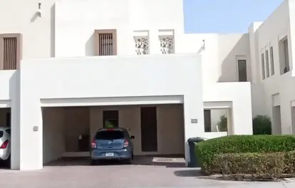 Discover the elegance of a contemporary 3-bedroom villa in Mira Oasis, featuring a sleek white exterior and a covered driveway with a striking blue car parked out front. The upstairs windows are adorned with geometric patterns, adding a touch of sophistication, while neatly trimmed hedges line the inviting entrance. Available for rent through Redlac Real Estate, your trusted partner in Dubais vibrant property market. Experience luxury living at its finest.