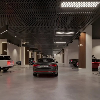 Discover modern luxury in Dubai with Redlac Real Estate. The VOLGA TOWERs underground parking garage showcases sophistication, housing SUVs and sedans in designated spaces. A smooth concrete floor and grid-patterned ceiling with integrated lighting enhance its sleek atmosphere. Trust Redlac to introduce you to premier properties like this, where elegance meets functionality.