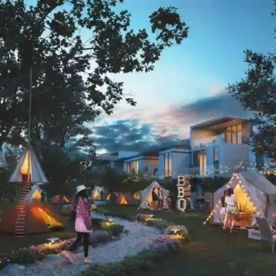 Capture the essence of an enchanting outdoor retreat: glowing tents nestled in a grassy haven, embraced by trees. As people savor a BBQ under twinkling string lights, modern homes grace the distant background against a dusk-hued sky. Experience unparalleled lifestyle opportunities with Redlac Real Estate in Dubai, where urban luxury meets serene natural beauty—your dream escape awaits!.