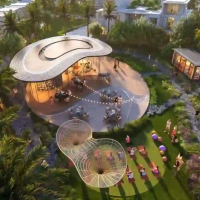 Experience the allure of Sun City through a stunning aerial view showcasing its modern, circular outdoor pavilion with an eye-catching roof design, nestled amidst lush greenery and swaying palm trees. Nearby, a lively crowd gathers beside a vibrant playground and quaint structure. Envision such serenity with Redlac Real Estate in Dubai, where dream properties await to match this extraordinary lifestyle.