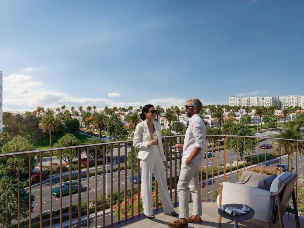 A couple enjoys a conversation on a balcony with a stunning cityscape view of palm trees and modern buildings, epitomizing luxury and convenience. The scene, featuring a clear sky and tastefully set table, captures the essence of upscale living. Experience this in Dubai with Redlac Real Estate—your gateway to elegance and sophistication in one of the worlds most vibrant cities. Discover your dream home today!.